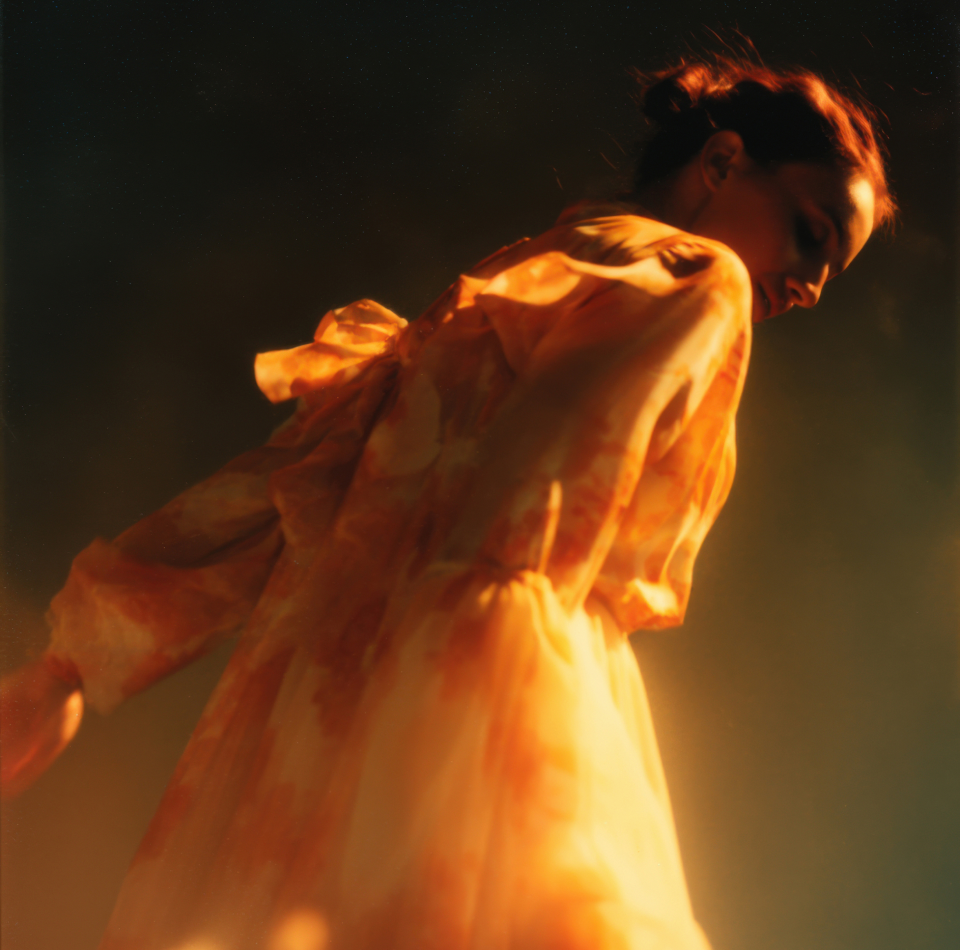 A person moving through warm orange light